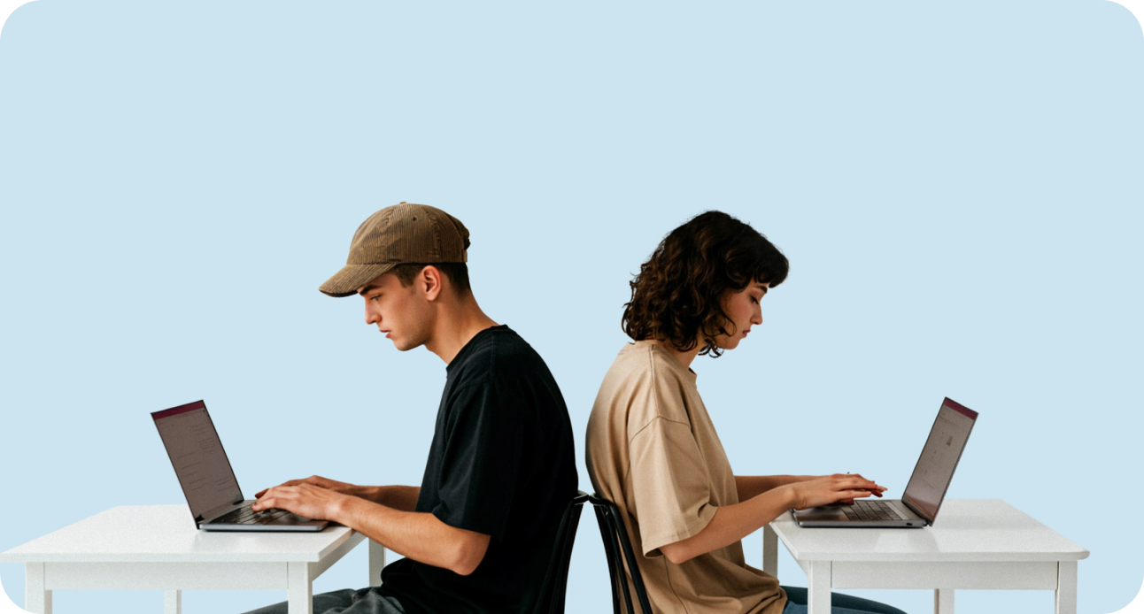 Two developers sitting back-to-back, each working on a laptop